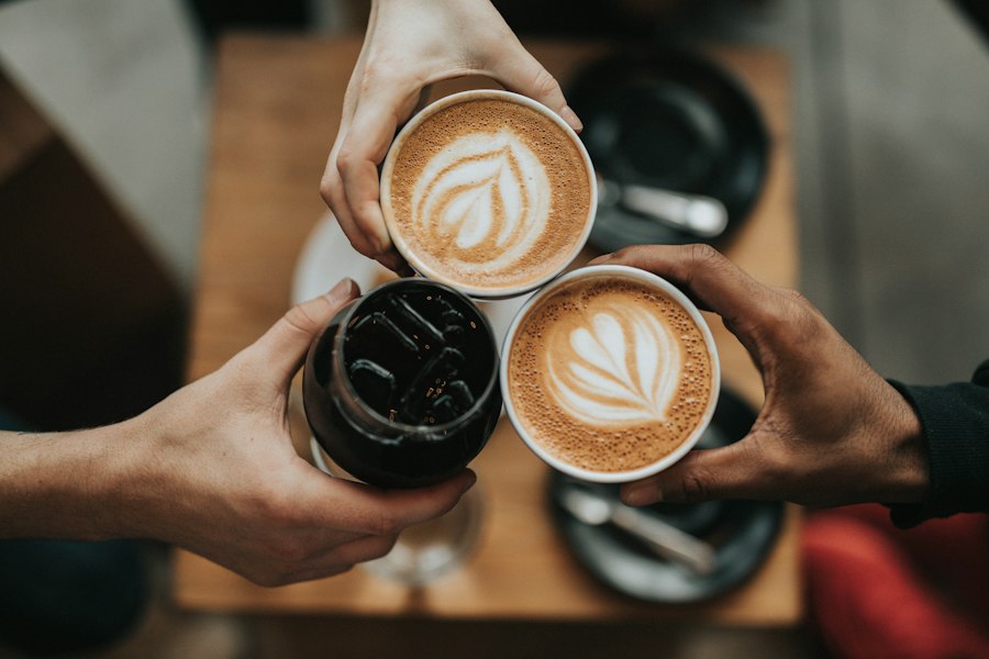 Hands holding two cups of coffee with latte art
