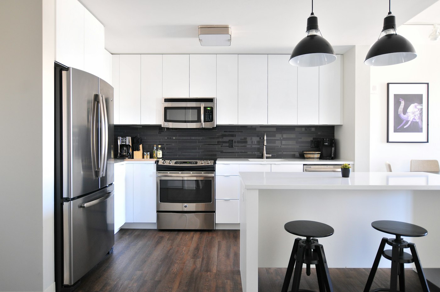 A white farmhouse kitchen with a large range and pendant lights