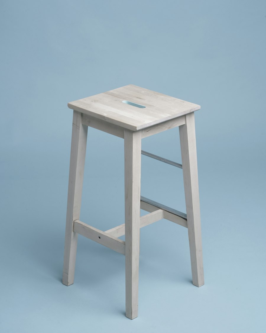 Halden stool in solid ash photographed against a pale blue background